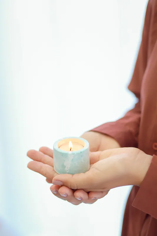 Vela acesa nas mãos de uma mulher